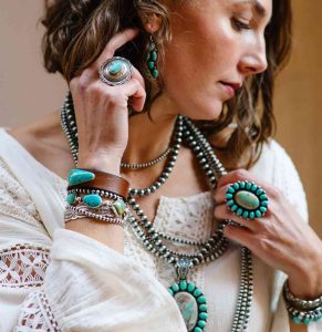 Woman wearing a turquoise crystal necklace in a summer outfit