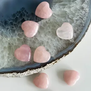 A person holding a rose quartz heart