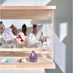 A beautifully organized display of various crystals in a collector’s cabinet